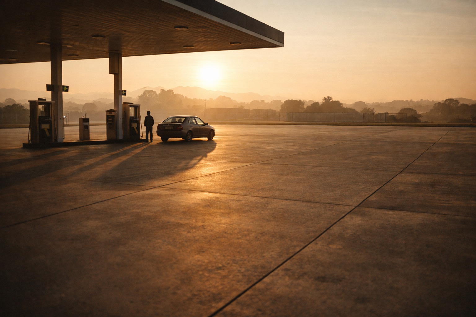 A lone driver at a petrol station before sunrise, the shift hasn't started
