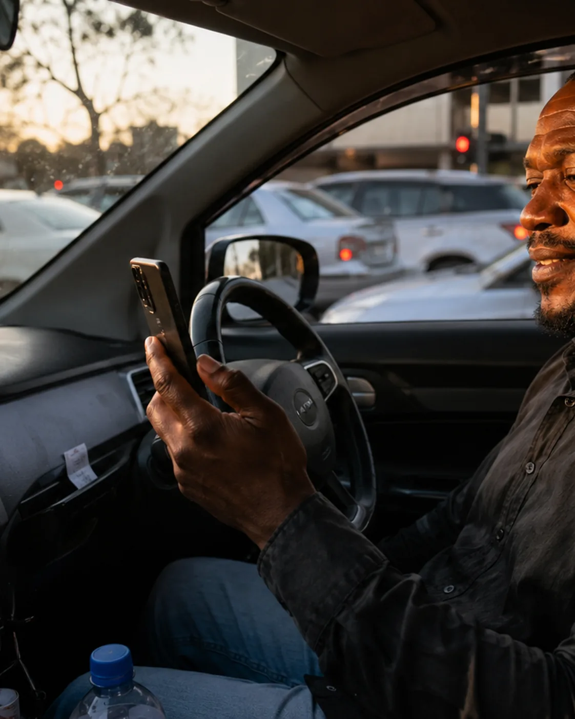 A driver checking his phone at the wheel in traffic