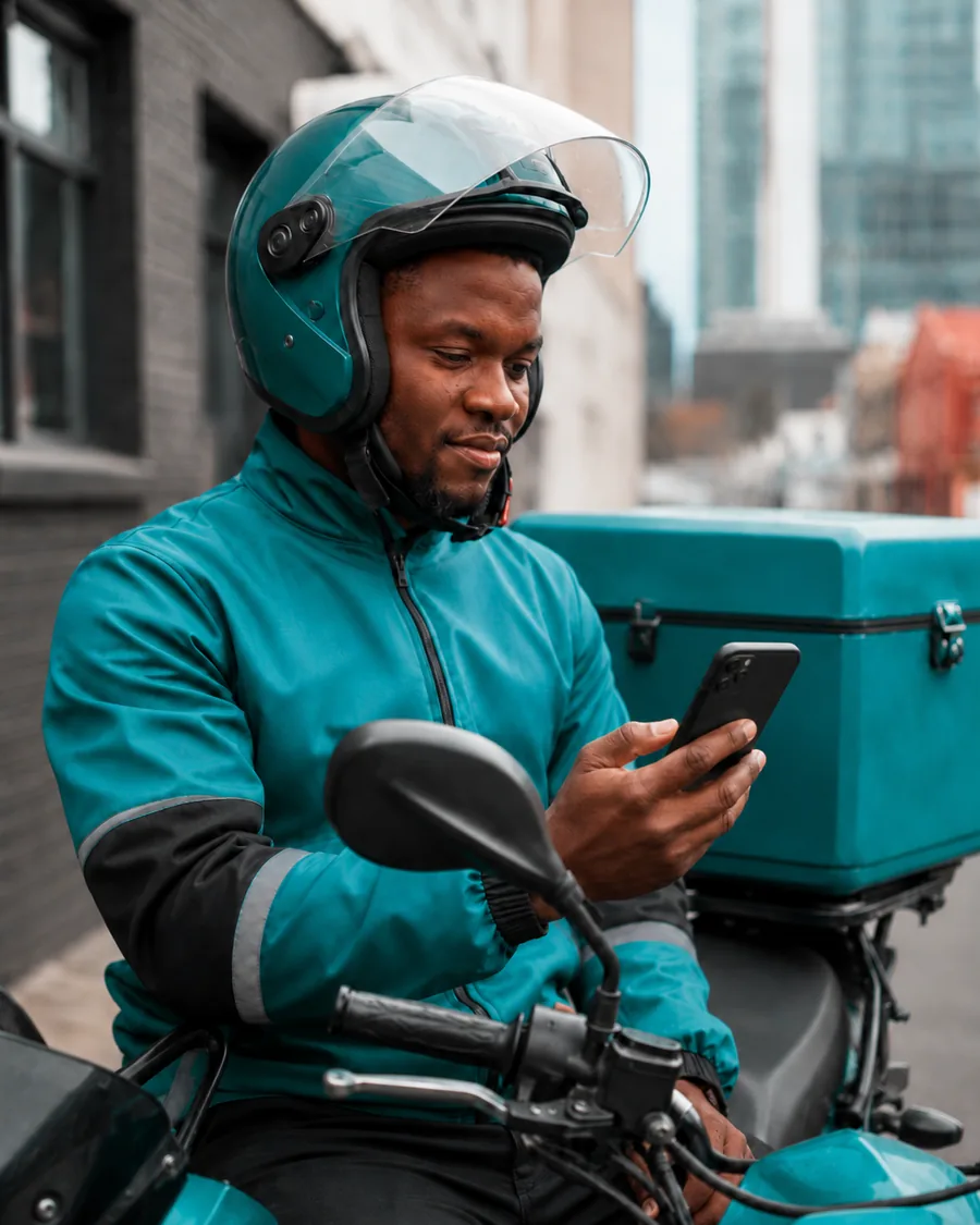 A delivery rider checking his phone at the start of a shift